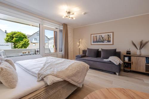 a bedroom with a bed and a couch and a window at Appartement Agnes in Westerland
