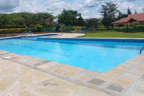 a large swimming pool with blue water at Juniper Park Resort in Nyahururu
