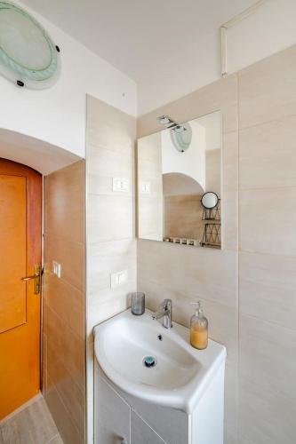 a white bathroom with a sink and a mirror at Gabri's Home in Spello