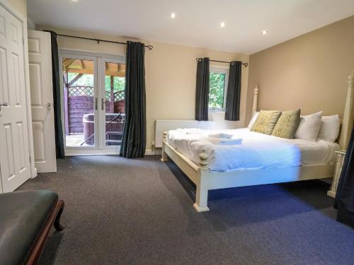 a bedroom with a white bed and a sliding glass door at The Red in St Asaph