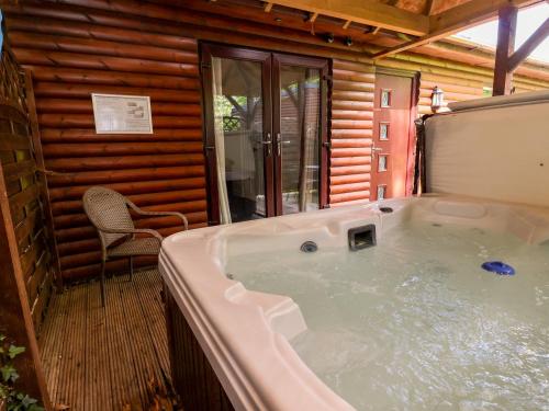 a jacuzzi tub in a log cabin at The Red in St Asaph