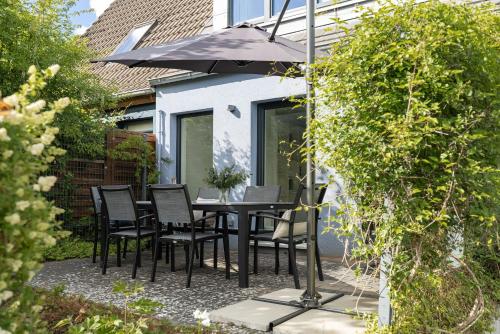 a patio with a table and chairs and an umbrella at Fischerhus Laboe in Laboe