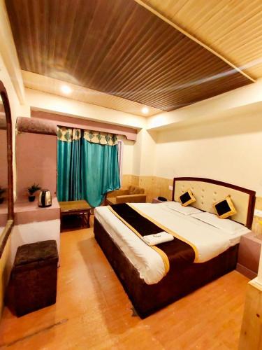 a bedroom with a large bed with green curtains at Regency Shooryaa Near The Mall Shimla in Shimla