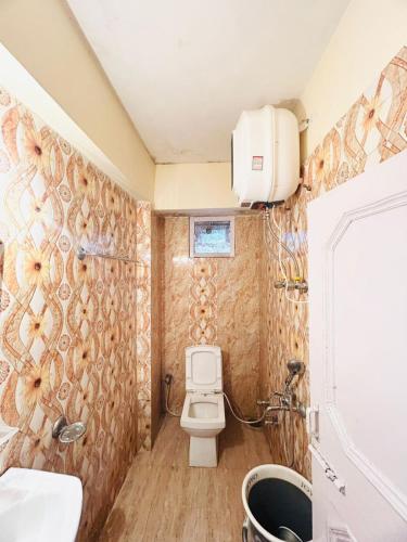 a bathroom with a toilet and a sink at Regency Shooryaa Near The Mall Shimla in Shimla