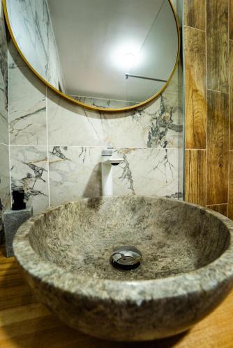 a large stone sink in a bathroom with a mirror at Belvedere Retezat in Cîmpu lui Neag