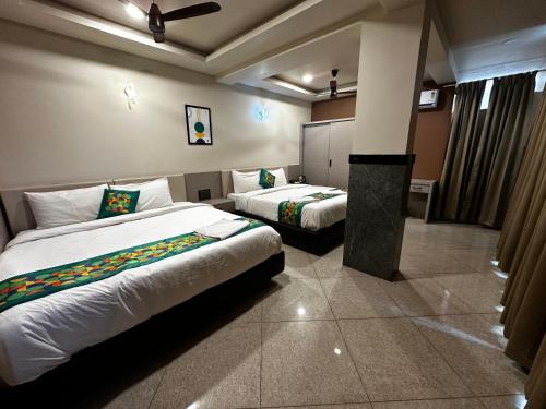 a hotel room with two beds in a room at Satkar Comforts in Attigundi