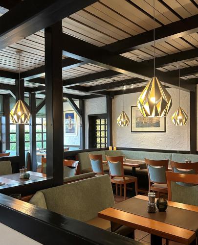a restaurant with tables and chairs and chandeliers at Hotel Pfälzer Hof GmbH in Braunschweig