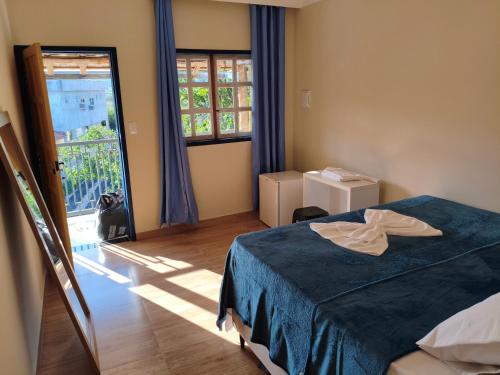 a bedroom with a bed and a large window at Felício Reis - Pousada Colonial in Conceição do Mato Dentro