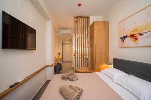 a bedroom with a bed and a flat screen tv at Perla Port Suites in Chios