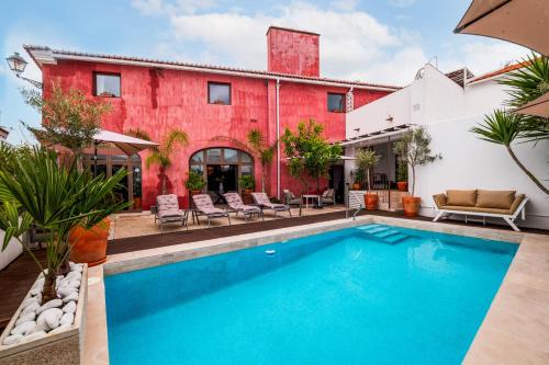 an outdoor swimming pool in front of a house at Quarto Duplo - Pacote Alentejo 3 Noites in Alcáçovas