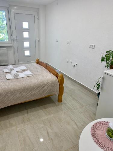 a bedroom with a bed with towels on it at Dora Apartman in Tomislavgrad