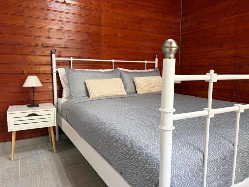 a bedroom with a white bed and a wooden wall at Rentdragoana in Costa Del Silencio