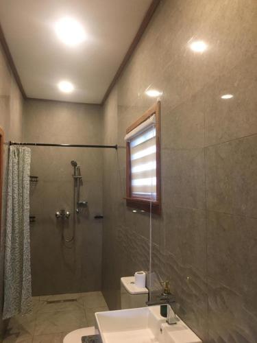 ein Badezimmer mit Dusche, Toilette und Waschbecken in der Unterkunft The Weekender in Kunkunu