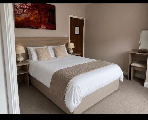 a bedroom with a large white bed with two night stands at Grove house Dunleer in Dún Léire