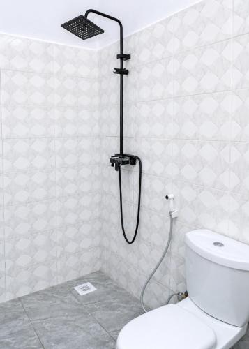 a shower in a bathroom with a toilet at Tumaini Bungalows in Nungwi