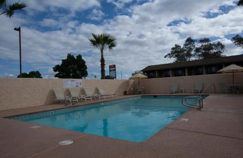 a large swimming pool with chairs and a building at Orland Inn in Orland