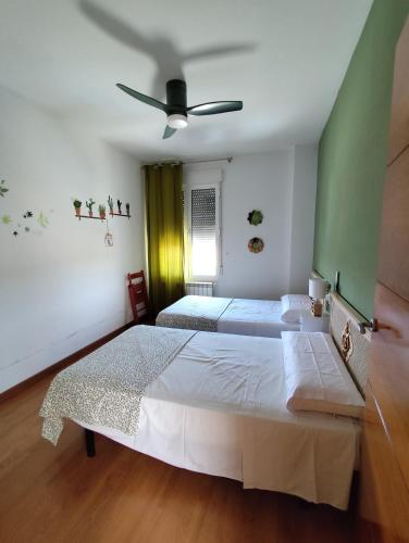 a bedroom with two beds and a ceiling fan at Casa Laureana in Ruidera