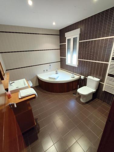 a bathroom with a tub and a toilet and a sink at Casa Laureana in Ruidera