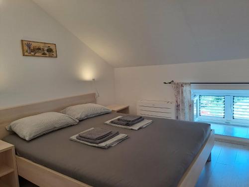 a bedroom with a bed with two towels on it at Greta in Vrbnik