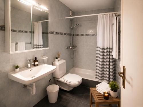 a bathroom with a sink and a toilet and a tub at KB CityRooms Self-Check-In in Lucerne