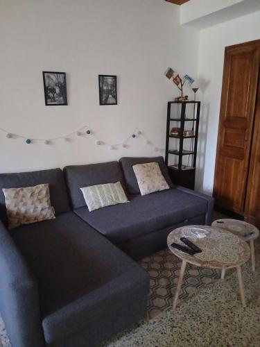 a living room with a blue couch and a table at Gîte des collines in Saint-Donat-sur-lʼHerbasse