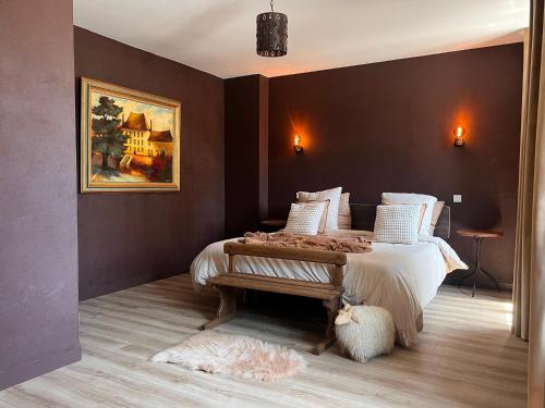a bedroom with a bed and a painting on the wall at La Maison du Cèdre in Bénévent-lʼAbbaye