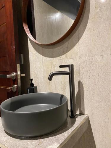 a sink in a bathroom with a mirror at Adisamasta Guesthouse in Sidemen