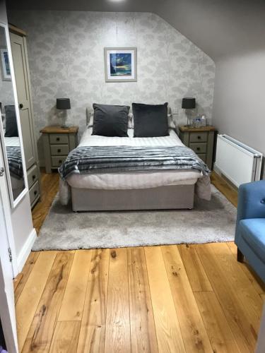 a bedroom with a bed and two night stands and a blue couch at The Bridge in Ballyconnell