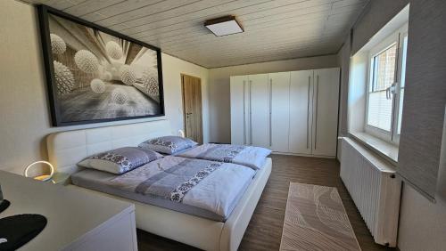 a bedroom with a bed with a picture on the wall at Auszeit Eifel Ihre private Auszeit zu zweit in Reuth