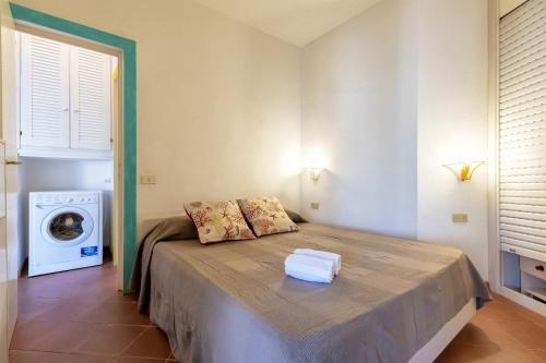 a bedroom with a bed and a washing machine at Appartamento "Hic et Nunc" in Costa Paradiso