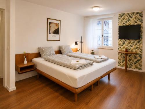 a bedroom with two beds and a flat screen tv at KB CityRooms Self-Check-In in Lucerne