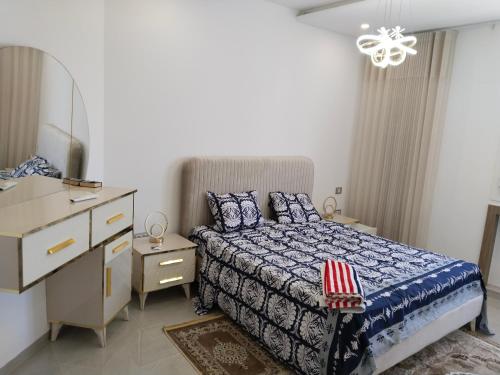 a bedroom with a bed and a dresser and a desk at Résidence Costa in Sousse
