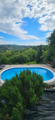 a large blue swimming pool with trees in the background at Relax House Lara in Krapinske Toplice in Krapinske Toplice