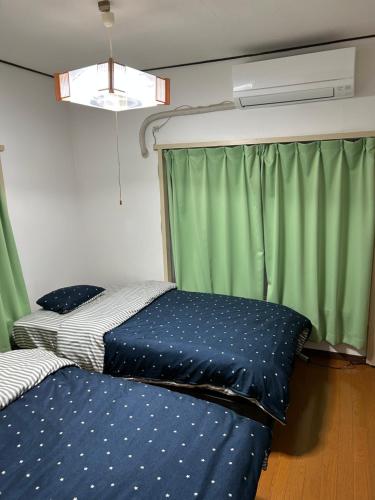 a bedroom with a bed and a window with green curtains at 馨誠小屋201 in Tokyo