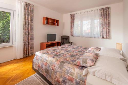 a bedroom with a bed and a desk and a window at House Nada 1201 in Banjole