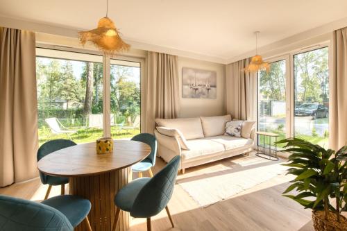 a living room with a couch and a table and chairs at Wydmove Łeba Q4 Apartments in Łeba