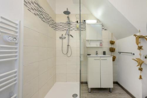 a white bathroom with a shower and a sink at Gite L'Aventura in Régades