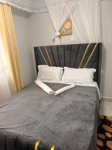 a bed with a black headboard and white pillows at Nalim bliss garden in Ruiru
