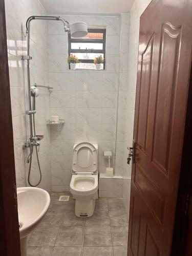 a bathroom with a toilet and a sink at Nalim bliss garden in Ruiru