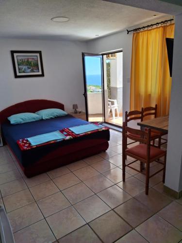 a bedroom with a bed and a table and a dining room at Apartments Petrovic in Krimovice