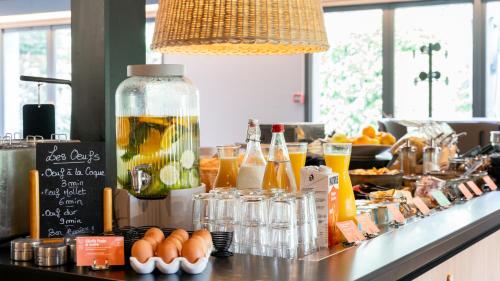 a bar with a bunch of drinks on a counter at Campanile NATURE - Vannes in Vannes