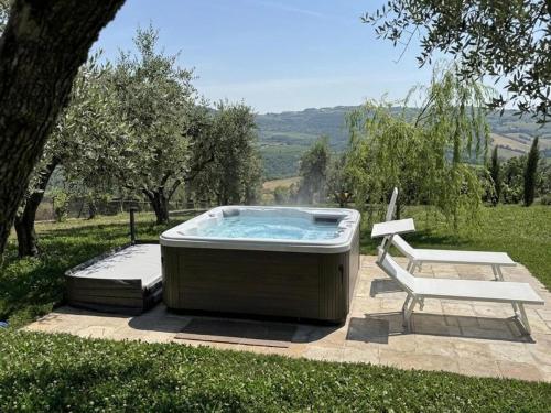 a hot tub with a bench and a chair at Ca' del Volo in Grezzana