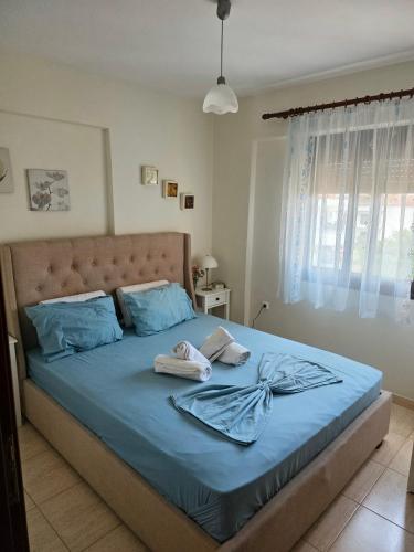 a bedroom with a blue bed with towels on it at Nice apartment with amazing views in Kriopigi