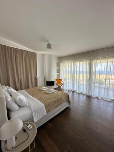 a bedroom with a large bed and a large window at Coastal Pool Hideaway in Loukísia