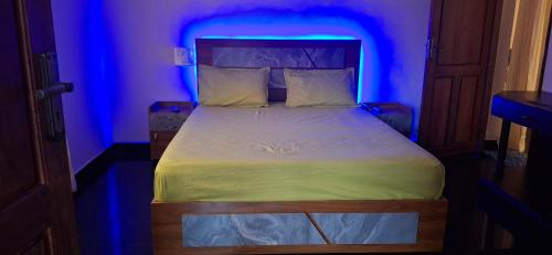 a bed in a room with a blue light at Smiley Homestay in Varkala