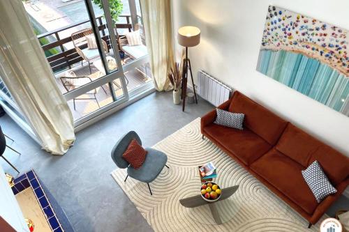 a living room with a couch and a table at Temps des Cerises - Terrasse - Plage - Marina in Deauville