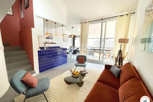 a living room with a couch and a chair at Temps des Cerises - Terrasse - Plage - Marina in Deauville