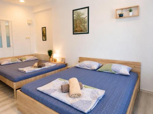 two beds in a room with blue sheets at Villa Jovan Gevgelija in Gevgelija
