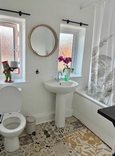 a bathroom with a sink and a toilet and a tub at Piotr House in Warrington