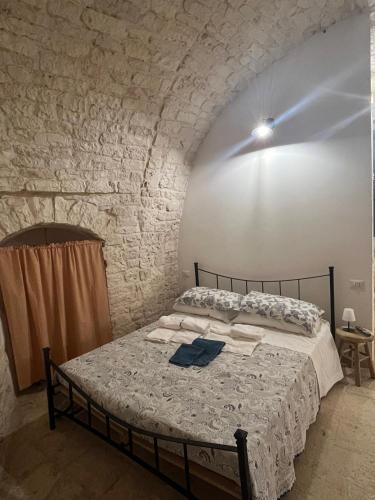 a bedroom with a bed in a brick wall at La casetta di Franci in Castellana Grotte